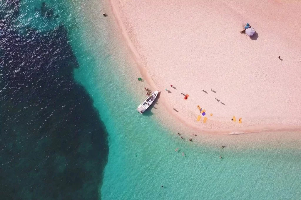Luchtfoto van een zandbank in het turquoise water van de Rode Zee met een bootje
